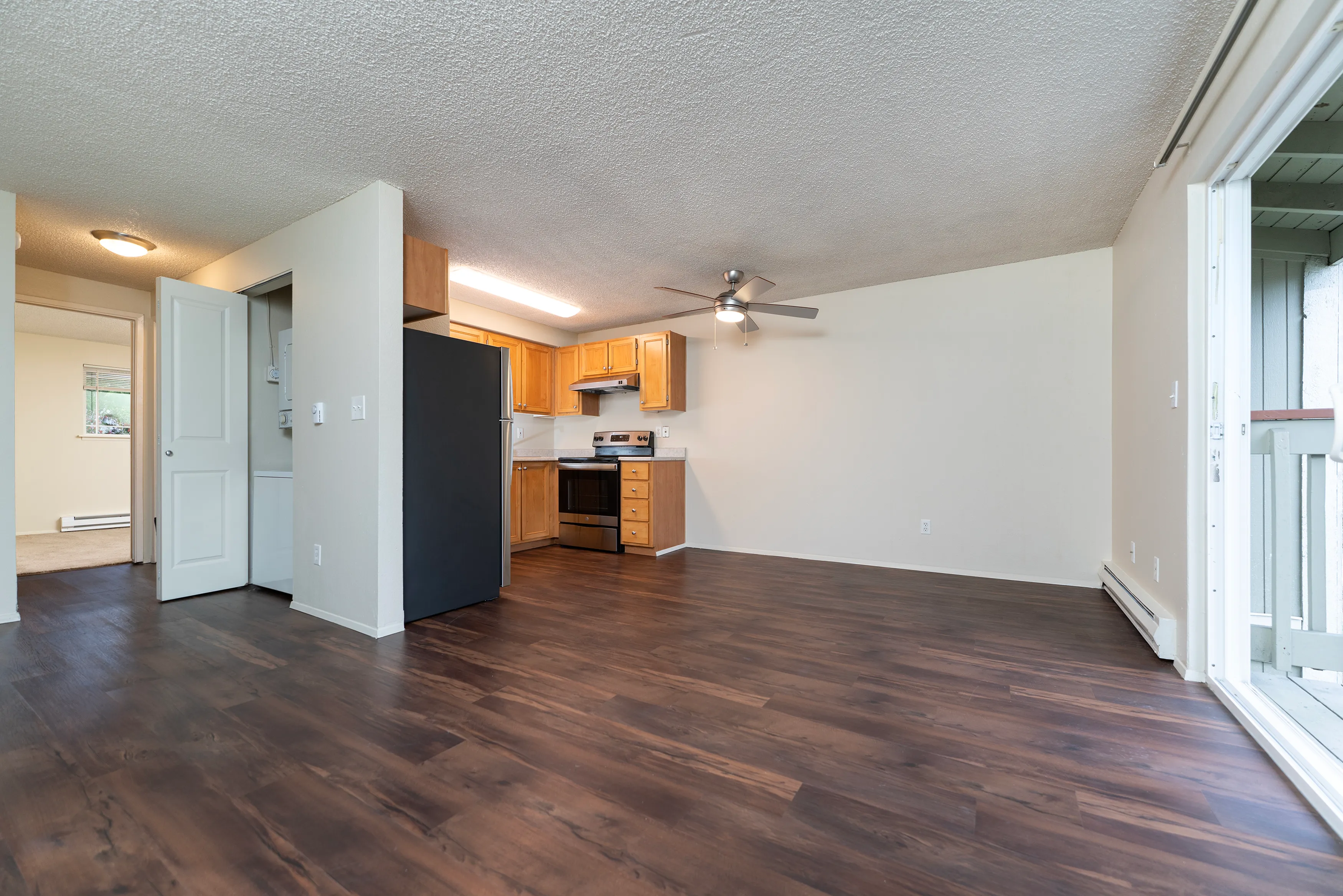 Bright open-concept living space featuring modern kitchen, elegant hardwood floors, and ample natural light.