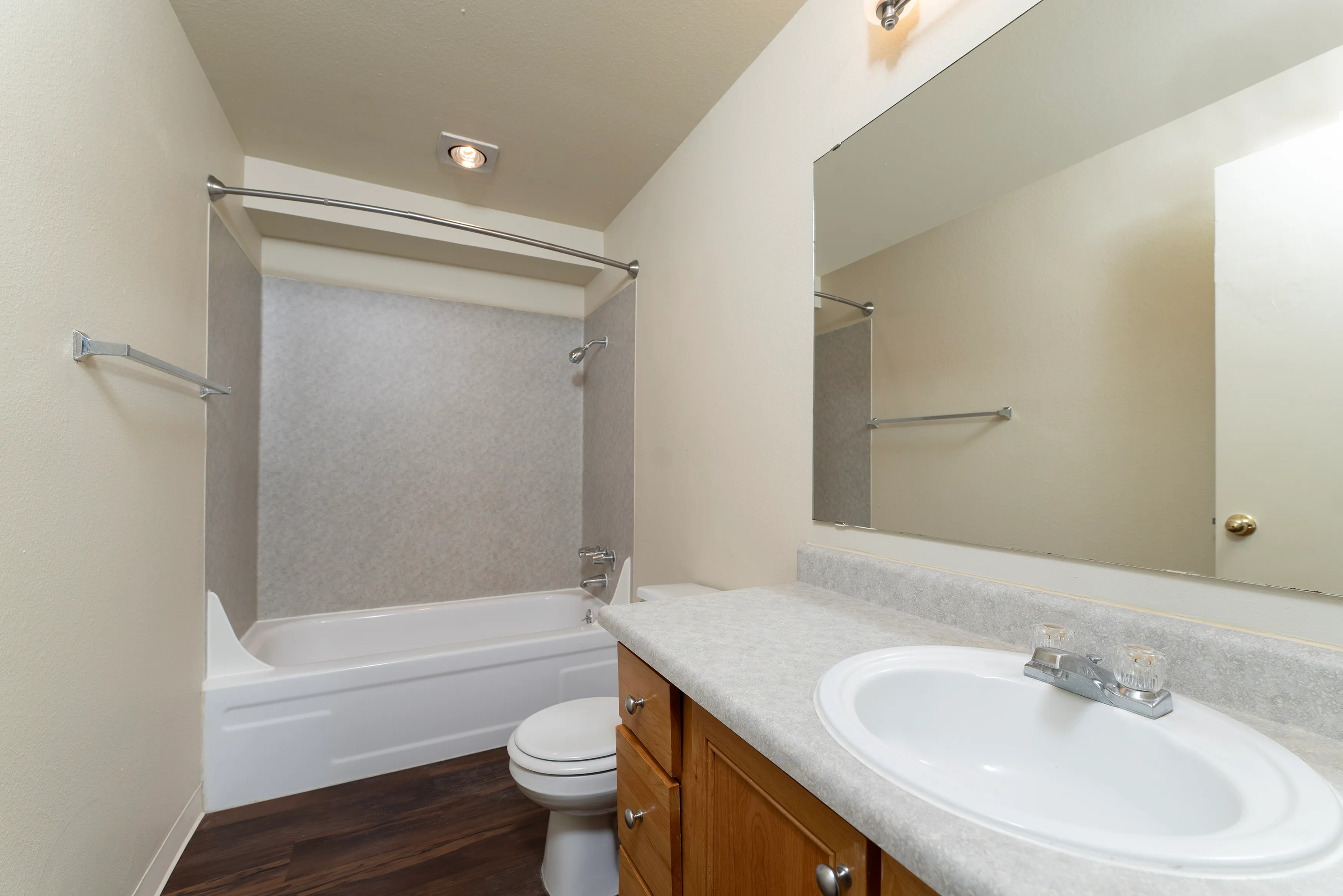 Modern bathroom with elegant fixtures, featuring a spacious bathtub, sleek vanity, and large mirror, perfect for relaxation and convenience.