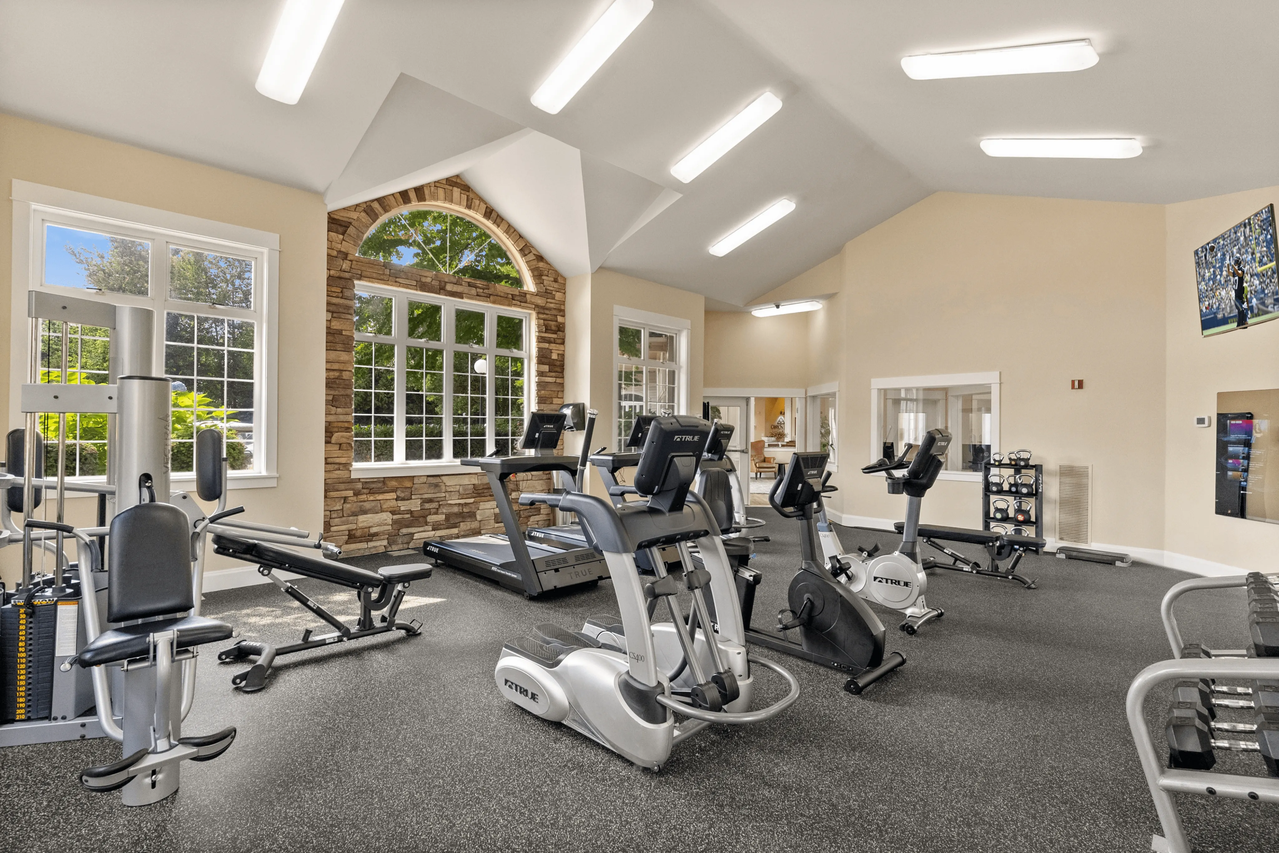 Bright and inviting fitness center with modern exercise equipment and large windows offering scenic views.
