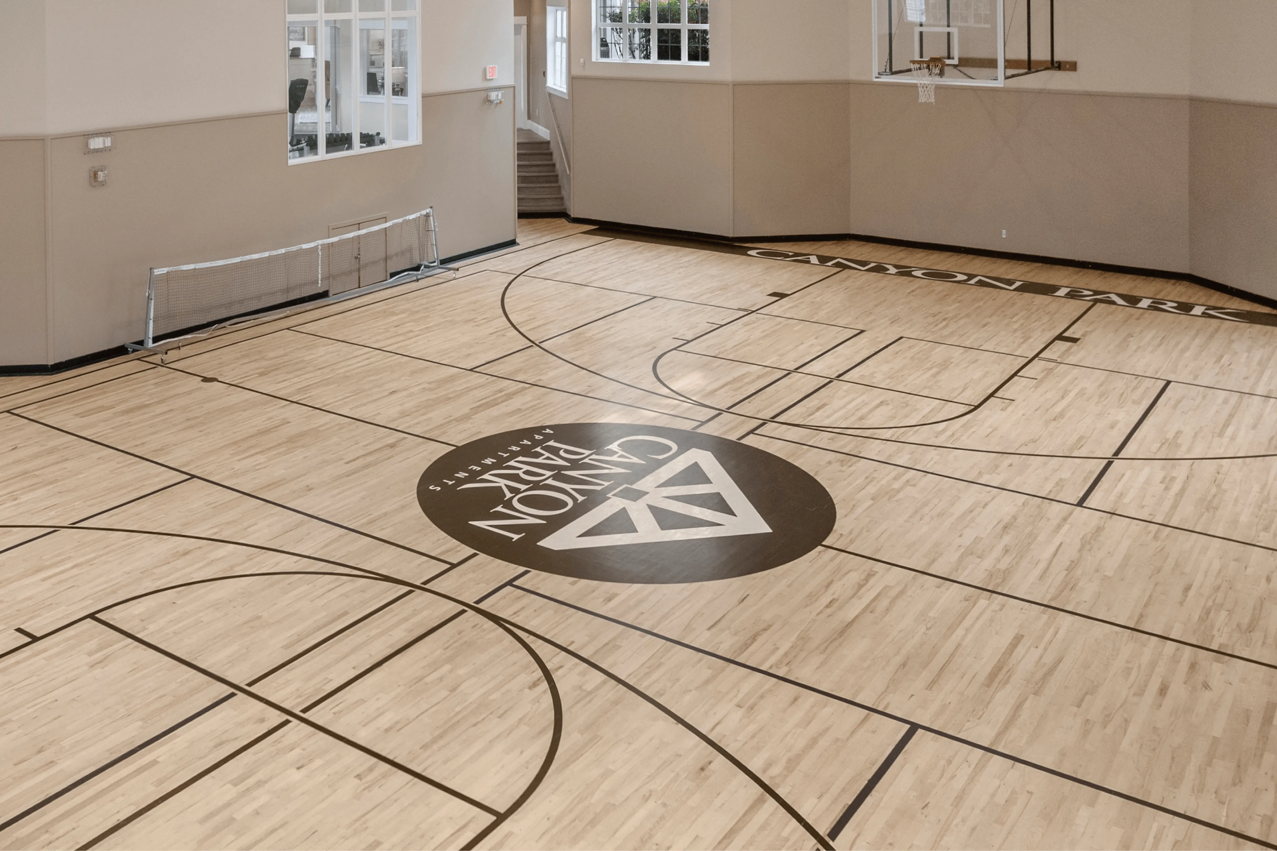 Elegant indoor basketball court with polished wood flooring, perfect for recreational activities at Canyon Park Apartments.