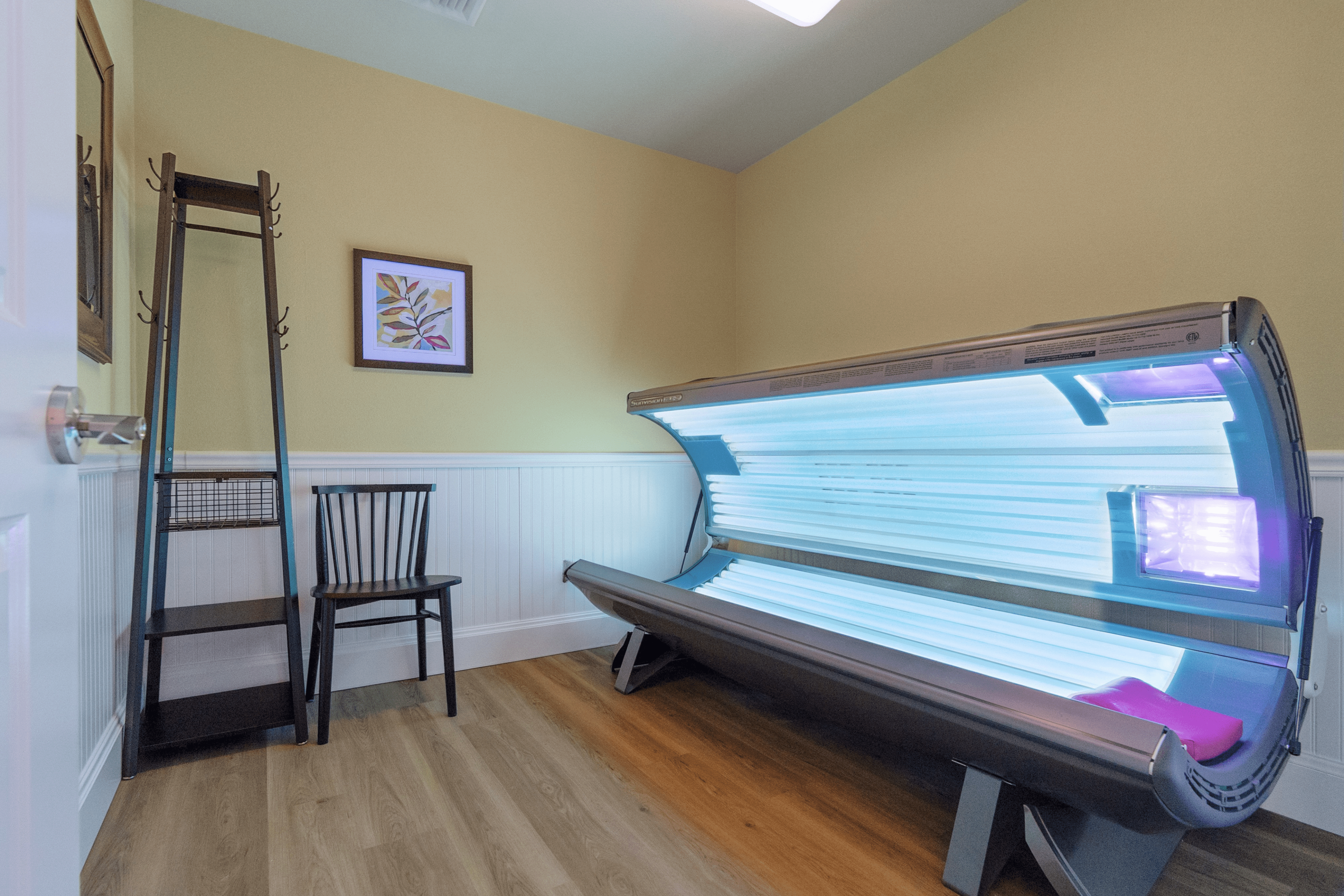 Inviting room featuring a modern tanning bed under soft lighting, perfect for a relaxing and rejuvenating experience in a cozy environment.
