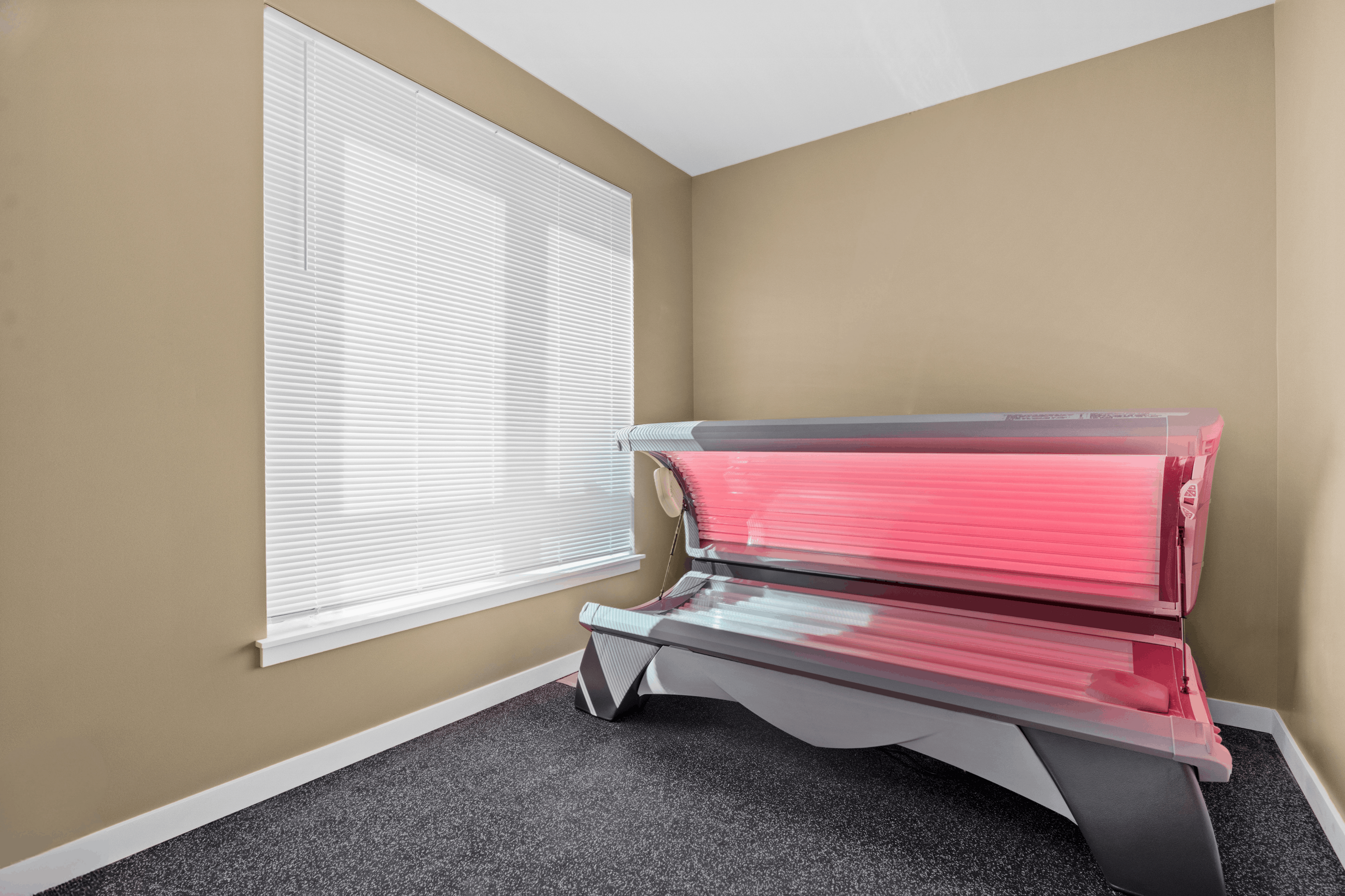 Modern apartment room with sleek indoor tanning bed and stylish window blinds, creating a relaxing and luxurious vibe.