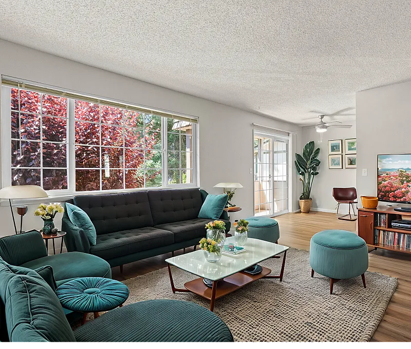 Modern living room with elegant furniture, large windows, and vibrant decor.