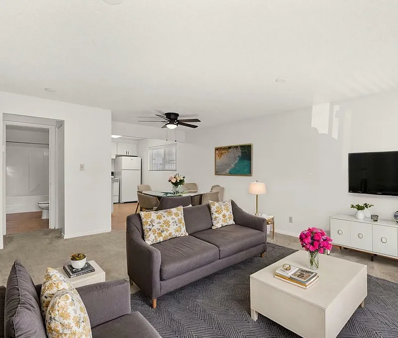 Bright and modern living room with stylish decor, cozy seating area, and wall-mounted TV.