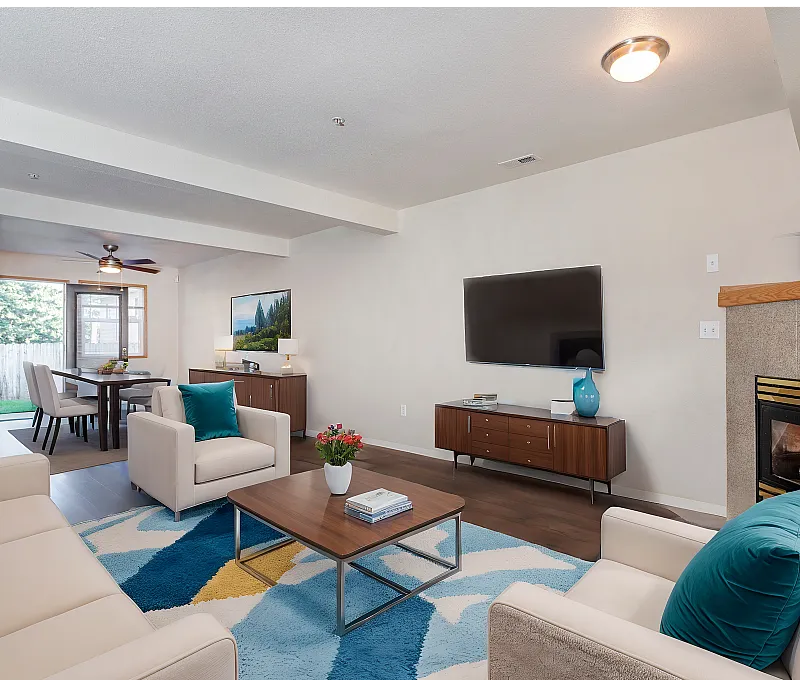 Elegant living room featuring modern decor, cozy fireplace, and open dining area, perfect for relaxation and entertaining.