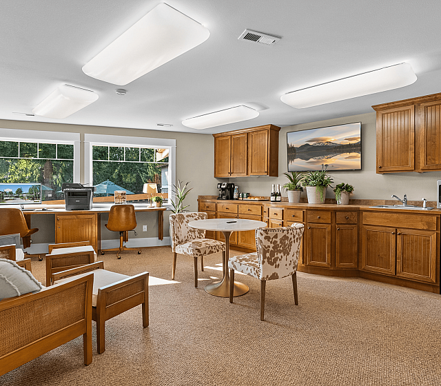 Inviting living space featuring warm wood cabinetry, stylish seating, and large scenic windows providing abundant natural light.