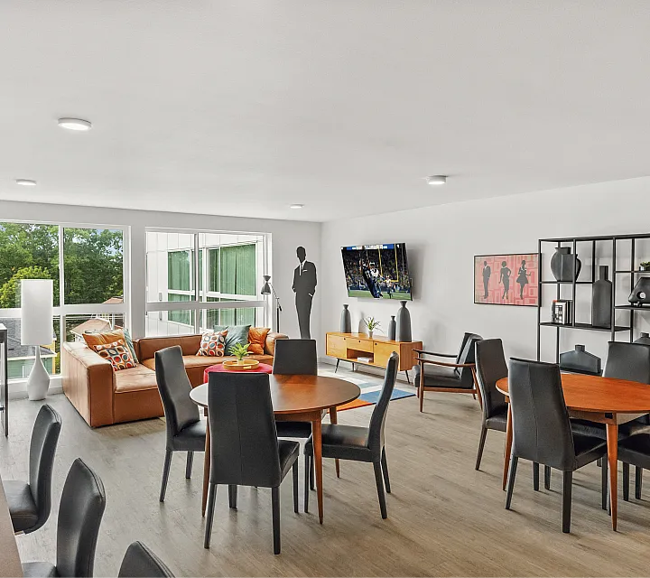 Modern and spacious open-concept living area boasting stylish decor, comfortable seating, and ample natural light from large windows.