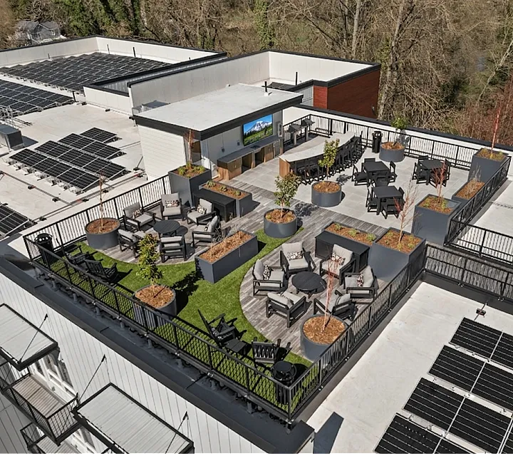 Luxurious rooftop lounge with stylish seating areas, lush greenery, and solar panels, offering a perfect blend of relaxation and sustainability.