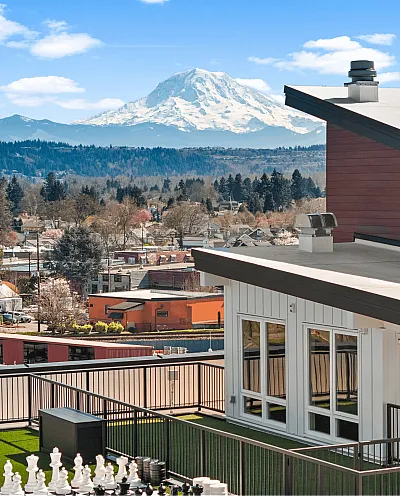 Stunning rooftop view with a majestic mountain backdrop, showcasing a sleek balcony and modern architectural style.