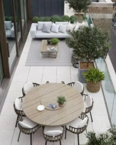Elegant outdoor patio with a modern round dining table, chic seating, lush greenery, and cozy lounge area.