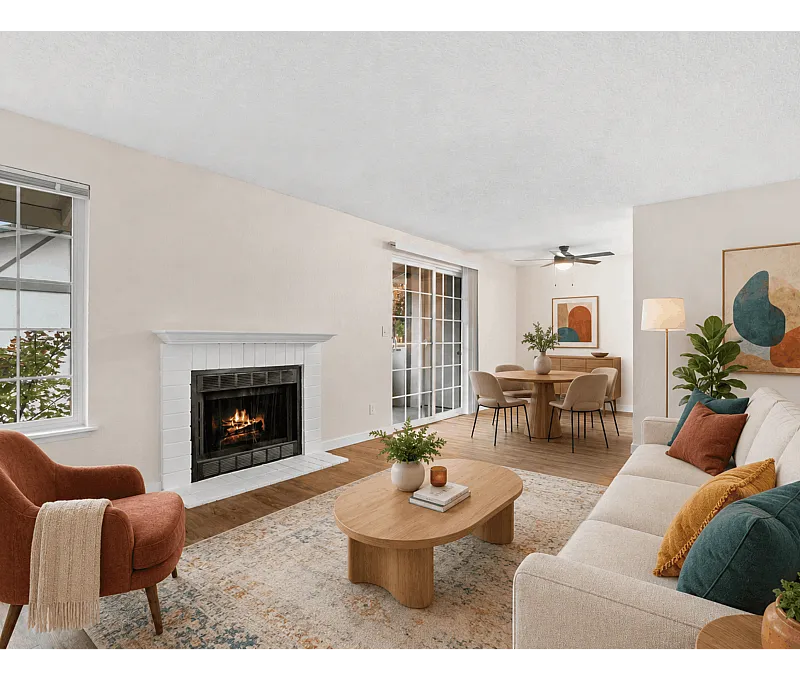 Inviting living room with a cozy fireplace, modern decor, and a view of the lush outdoor area through sliding glass doors.