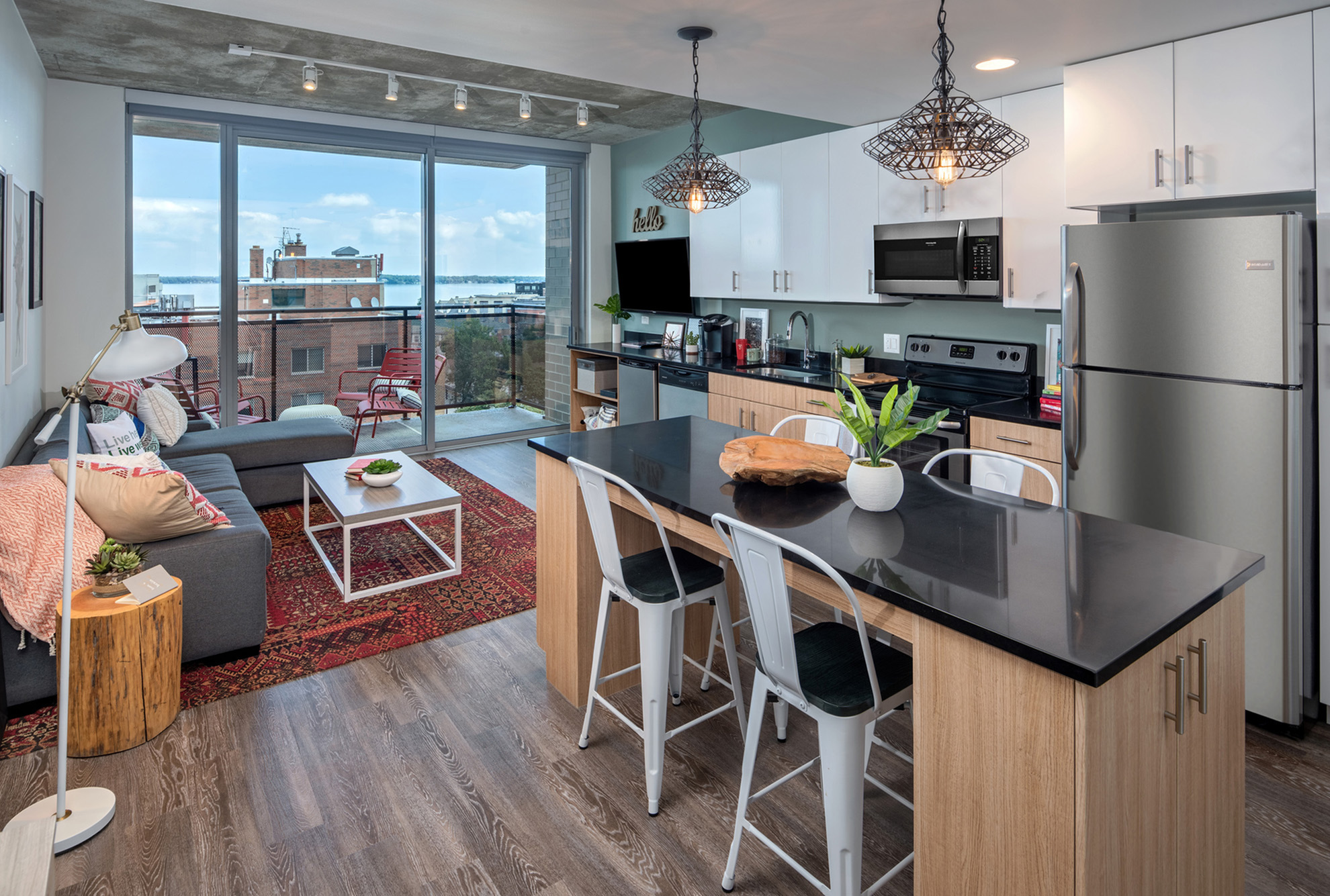 Model apartment kitchen and living room with floor to ceiling windows