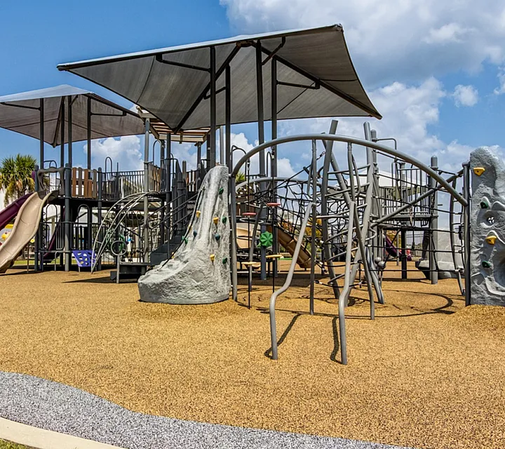 Playground with sun covers, covered picnic table pavilion area, climbing playground, swings, etc.