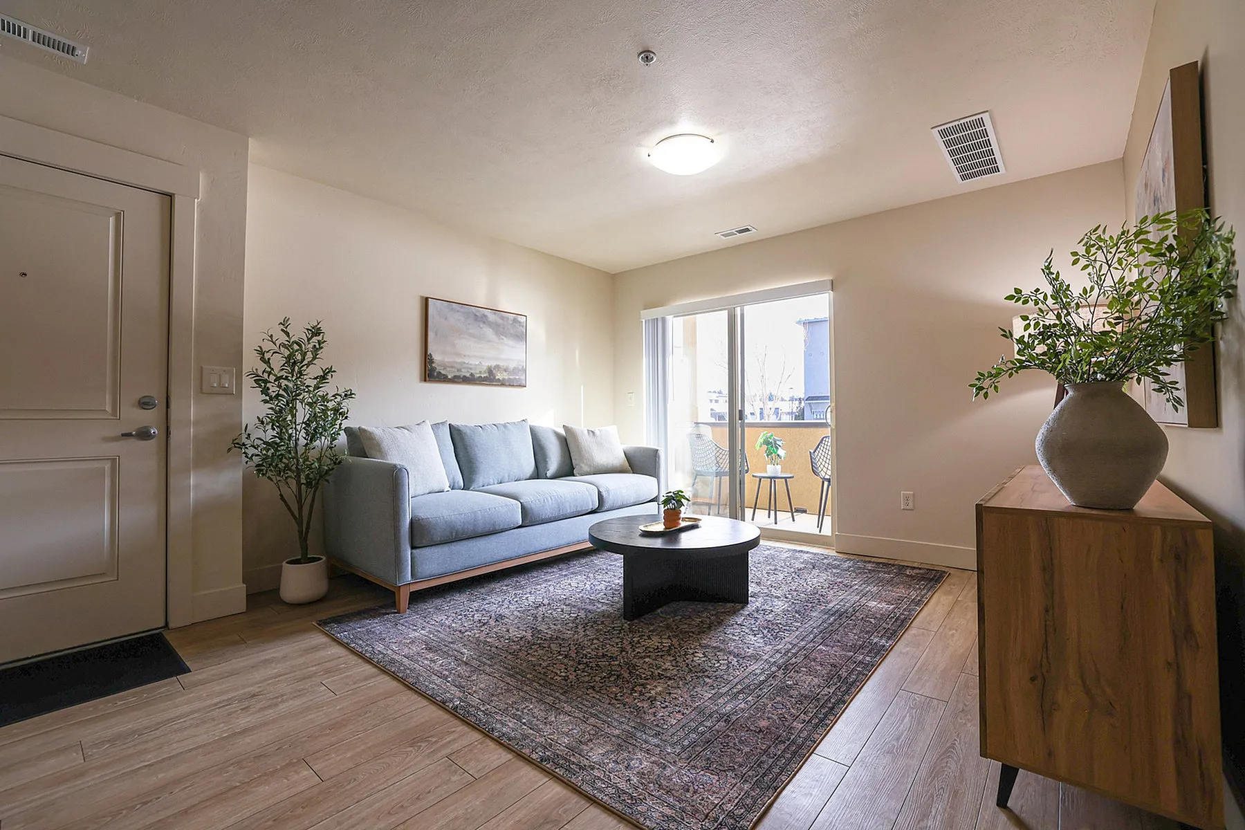 Inviting living room with a plush sofa, elegant coffee table, and access to a bright balcony.