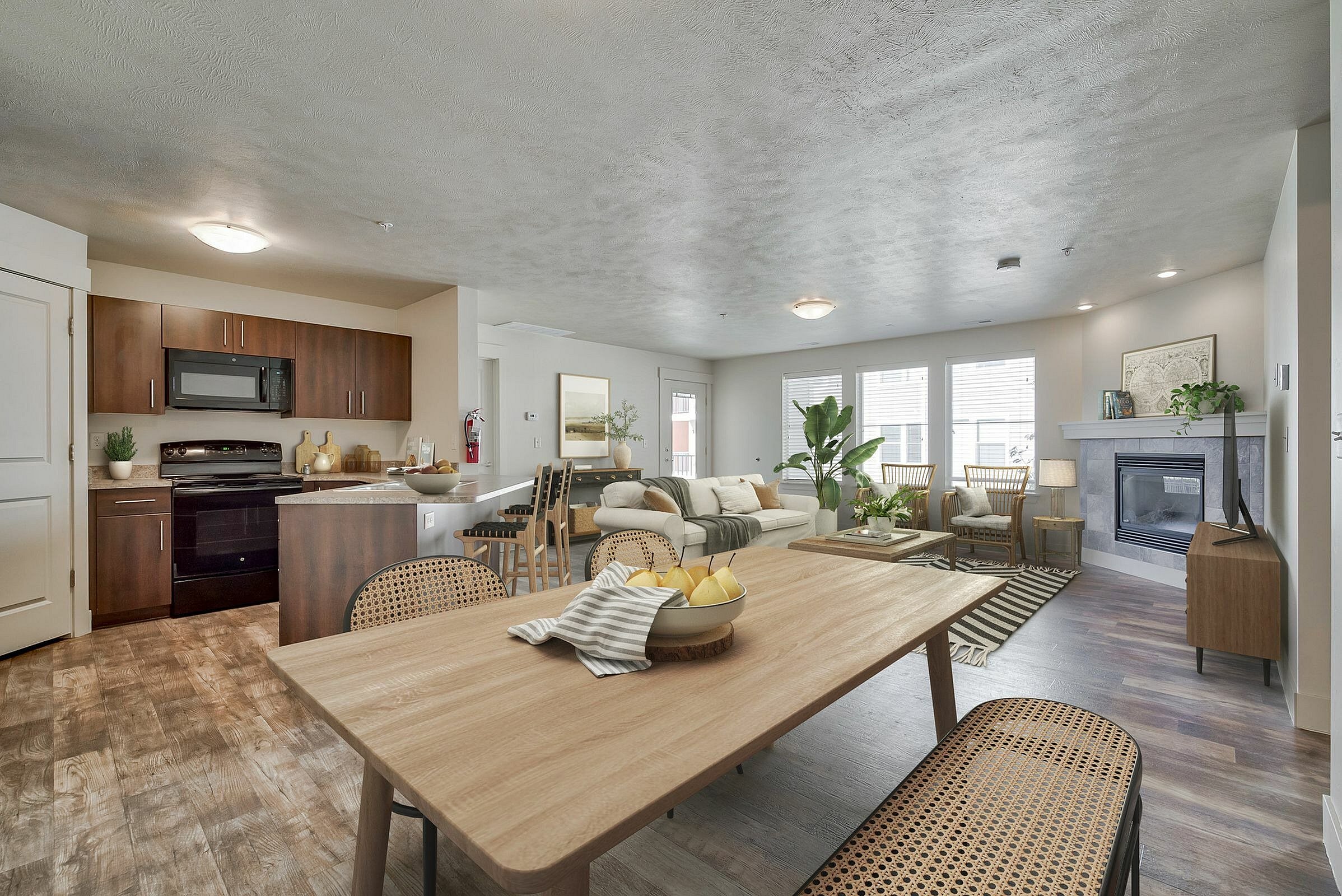 Bright and inviting open-concept living area featuring a modern kitchen, cozy living room with a fireplace, and stylish wooden dining table, perfect for entertaining.