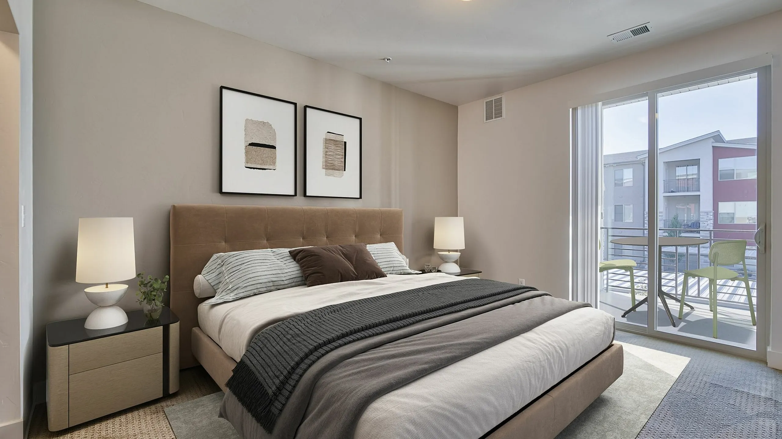 Elegant bedroom with plush king-sized bed, modern decor, and large sliding glass doors opening to a sunny balcony view.