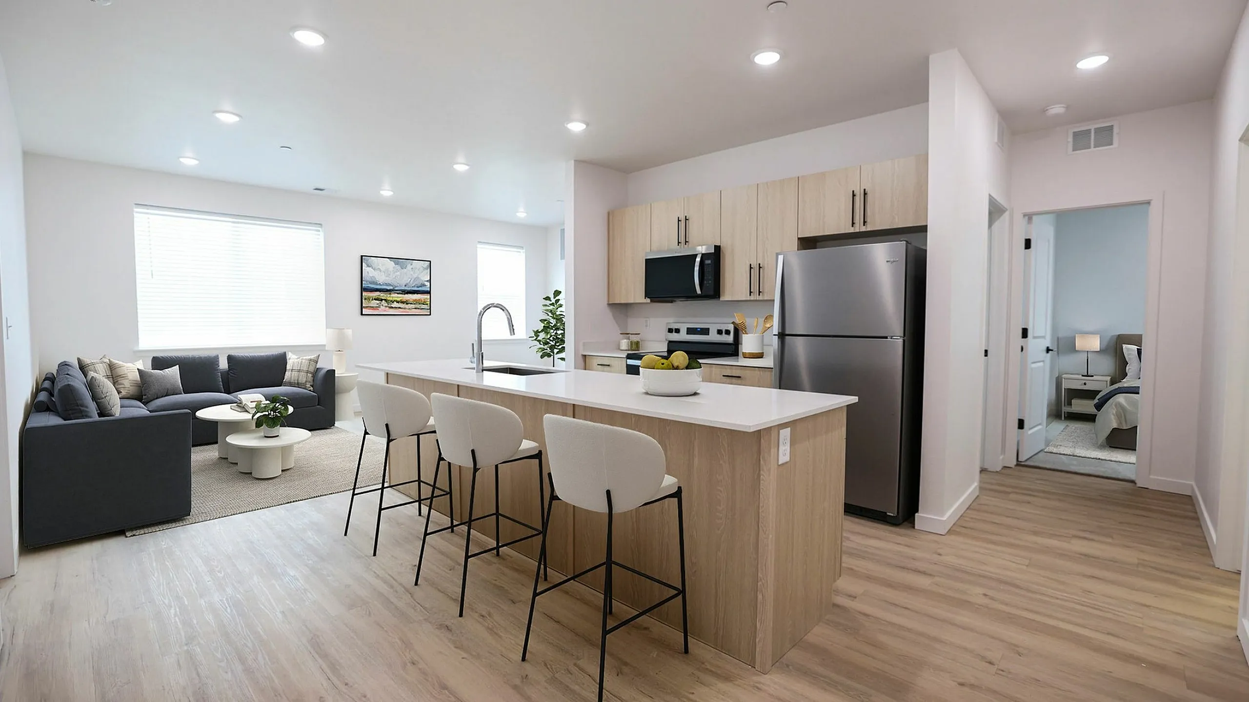 Elegant modern kitchen with stylish seating, open living area, and a cozy bedroom view, showcasing sleek appliances and bright natural lighting.