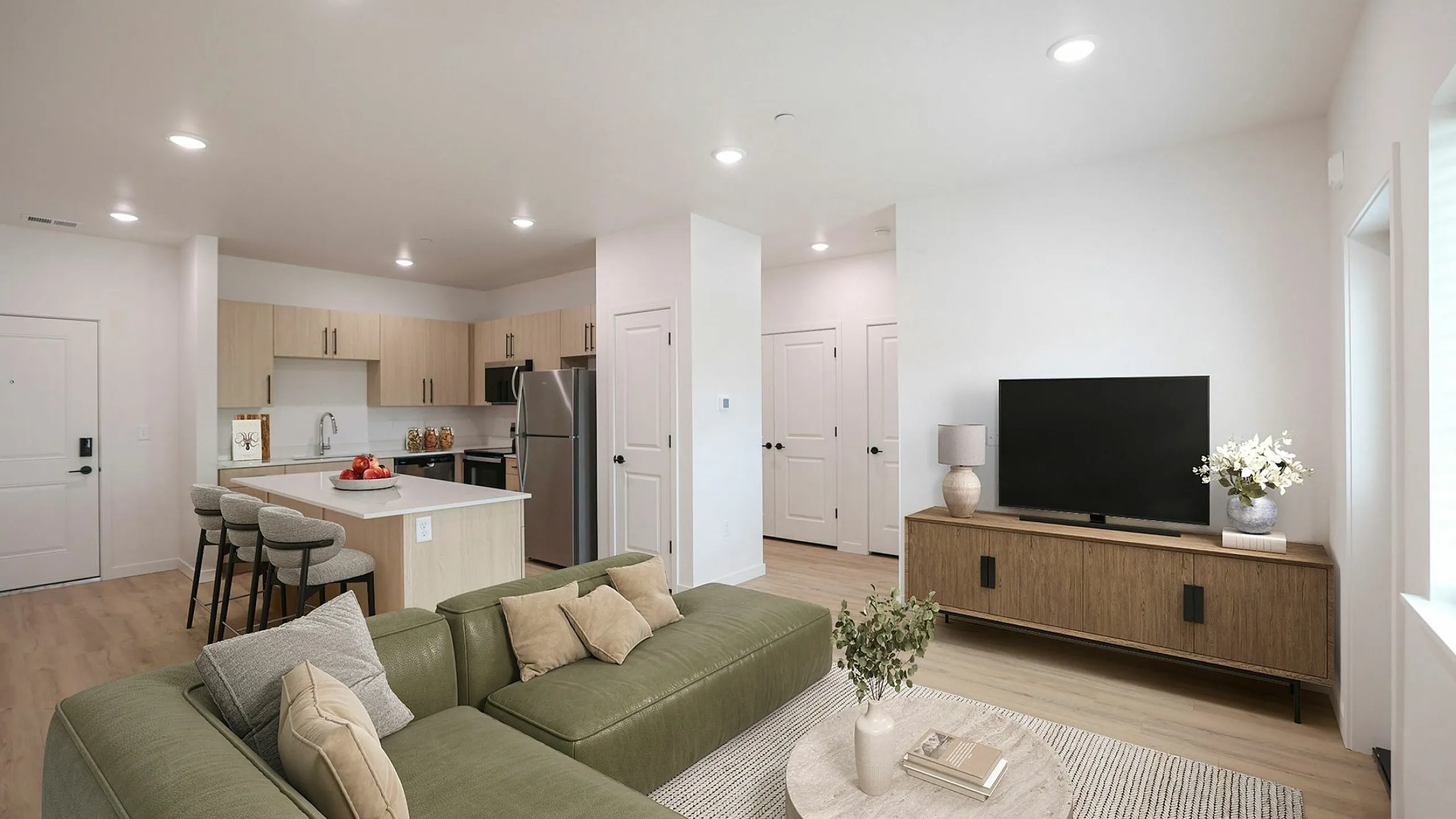 Modern open-concept apartment with a cozy living area, sleek kitchen island, and elegant decor.