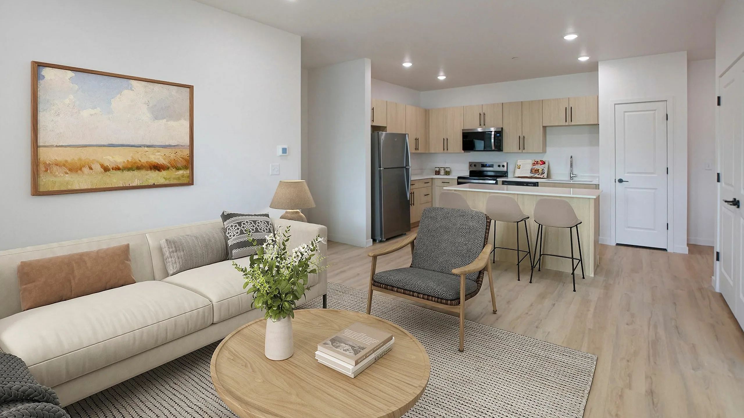 Modern open-plan living room and kitchen with elegant decor, featuring a cozy sofa, stylish chair, and breakfast bar with stools.