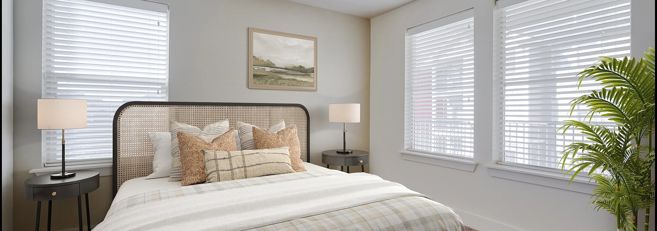 Inviting bedroom with a cozy plaid-covered bed, elegant nightstands, and abundant natural light from multiple windows, complemented by modern decor and a lush green plant.