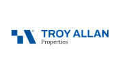 Logo for Troy Allan Properties featuring a modern design with a geometric symbol in blue and bold, elegant lettering.