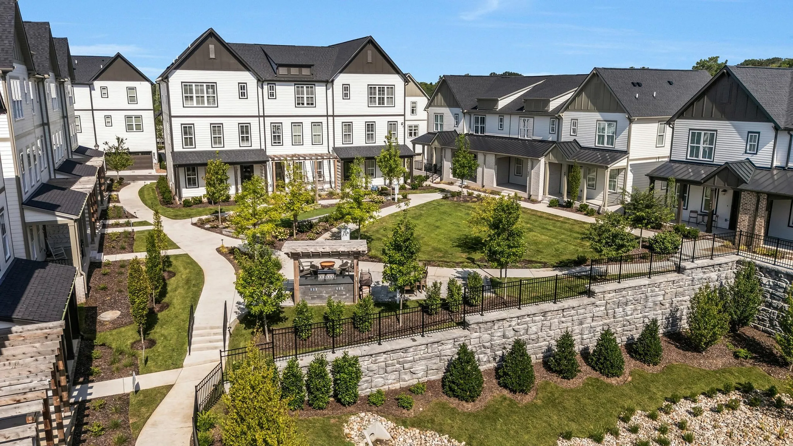 Charming townhouse community with modern architecture, lush green lawns, and inviting pathways for a serene neighborhood experience.