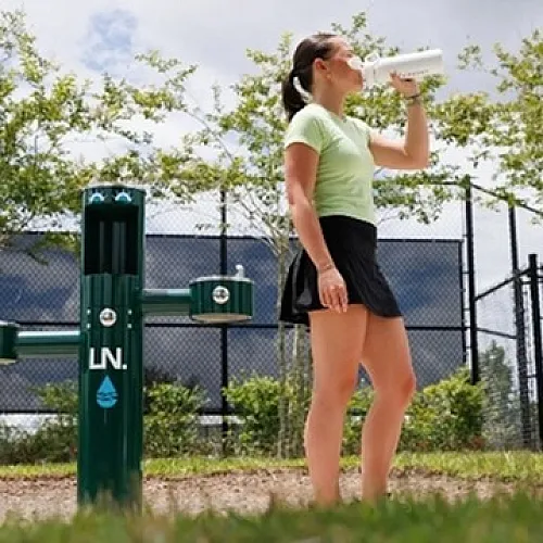 Refreshing outdoor drinking fountain in a sunny park setting, perfect for staying hydrated during recreational activities.