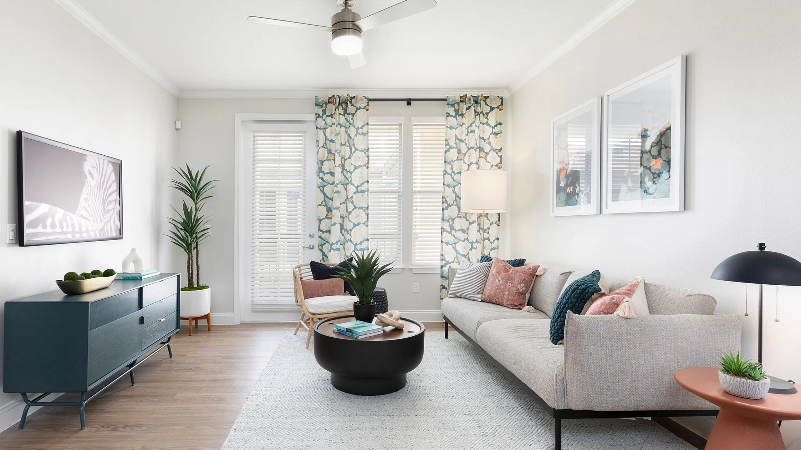 Bright, modern living room with stylish decor, featuring a sleek sofa, chic coffee table, and vibrant artwork in an airy space filled with natural light.