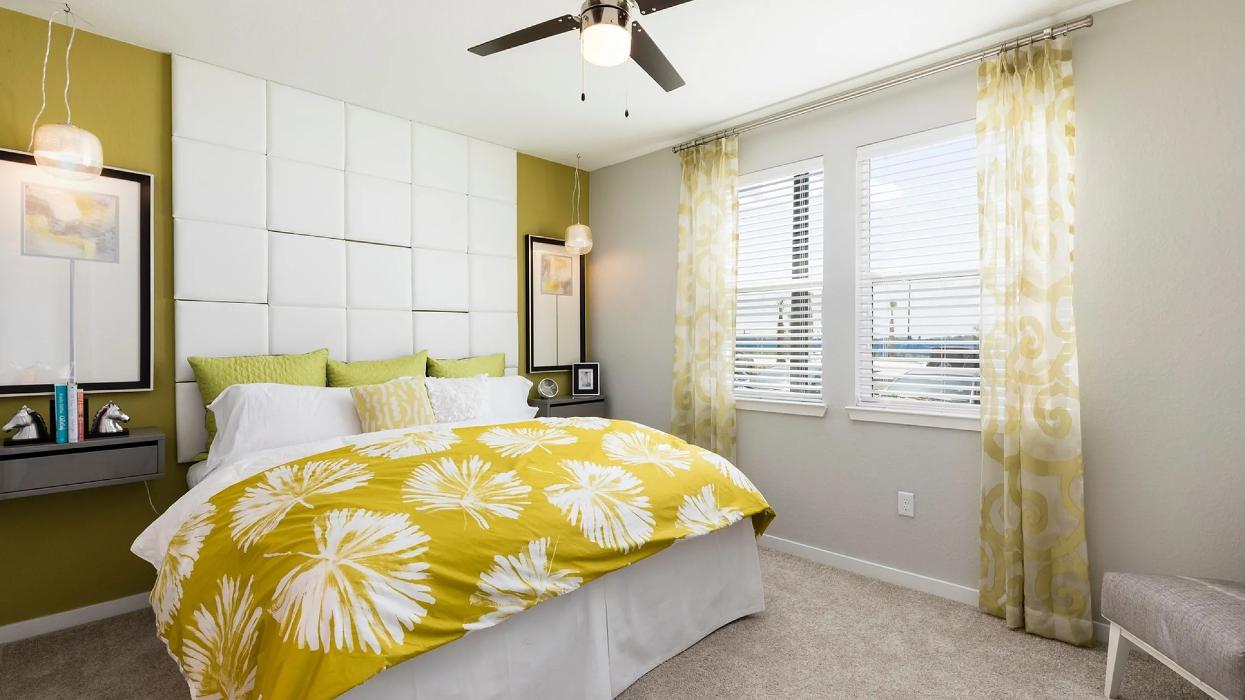 Bright and inviting bedroom with stylish green accents, featuring a plush bed with vibrant yellow floral bedding and elegant decor.
