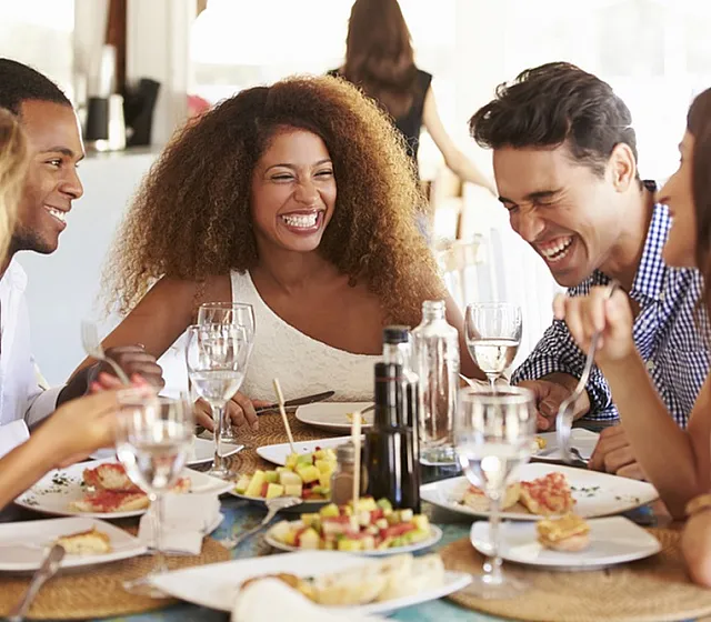 Vibrant gathering of friends enjoying a delightful meal together, filled with laughter and joy at a stylish dining table.