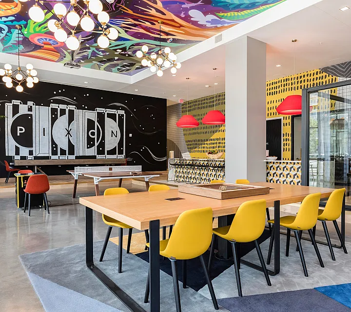 Vibrant communal area featuring colorful modern decor, spacious seating, and dynamic wall art, perfect for social gatherings and creative collaboration.