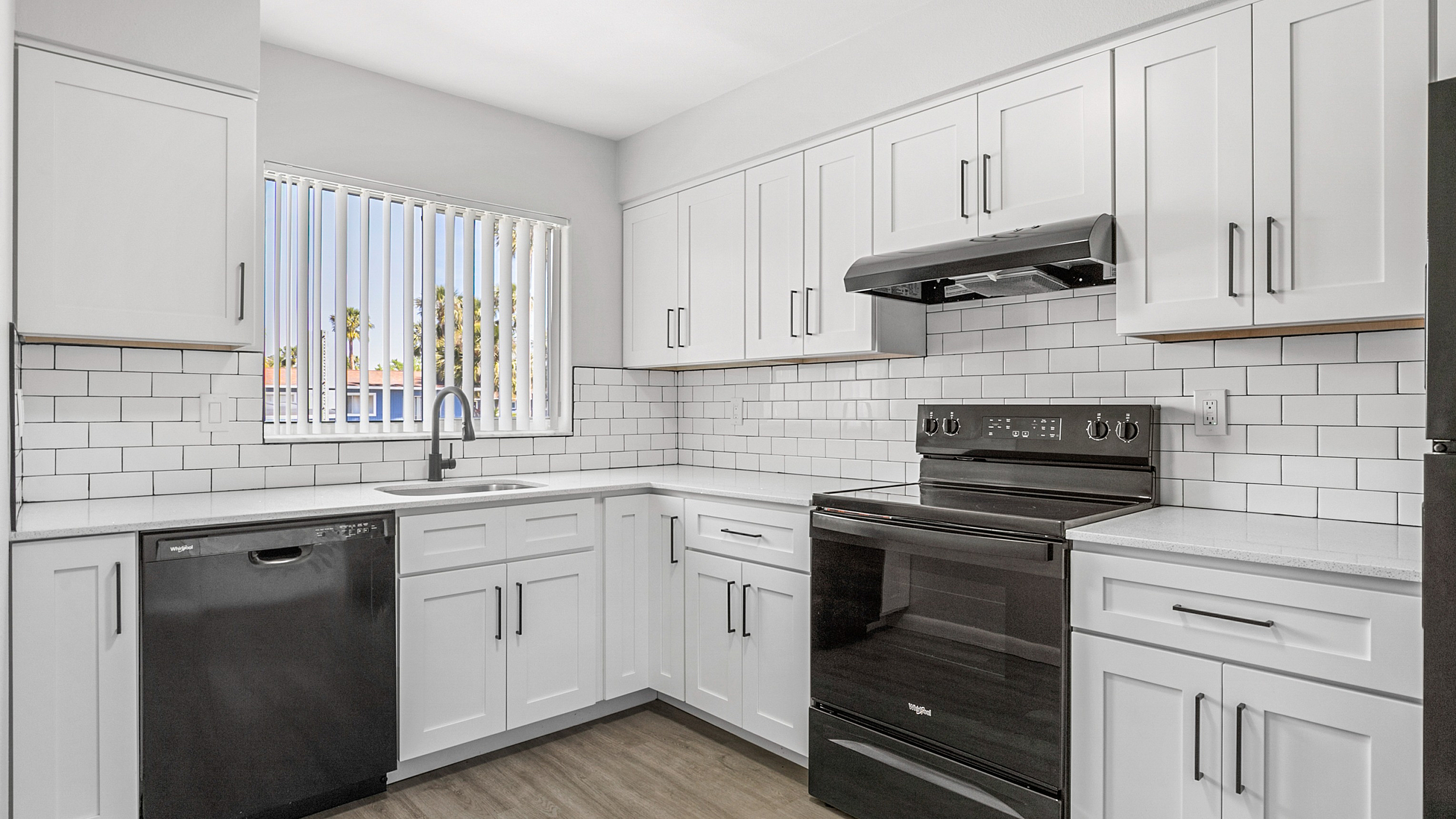 Modern kitchen with sleek white cabinets, elegant subway tile backsplash, and high-quality appliances.