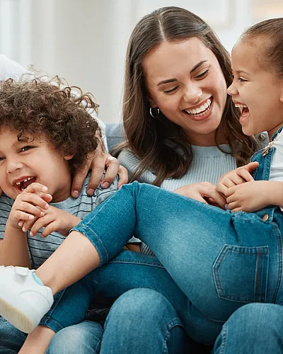 Happy family enjoying quality time together, laughing and bonding in a cozy living room setting.