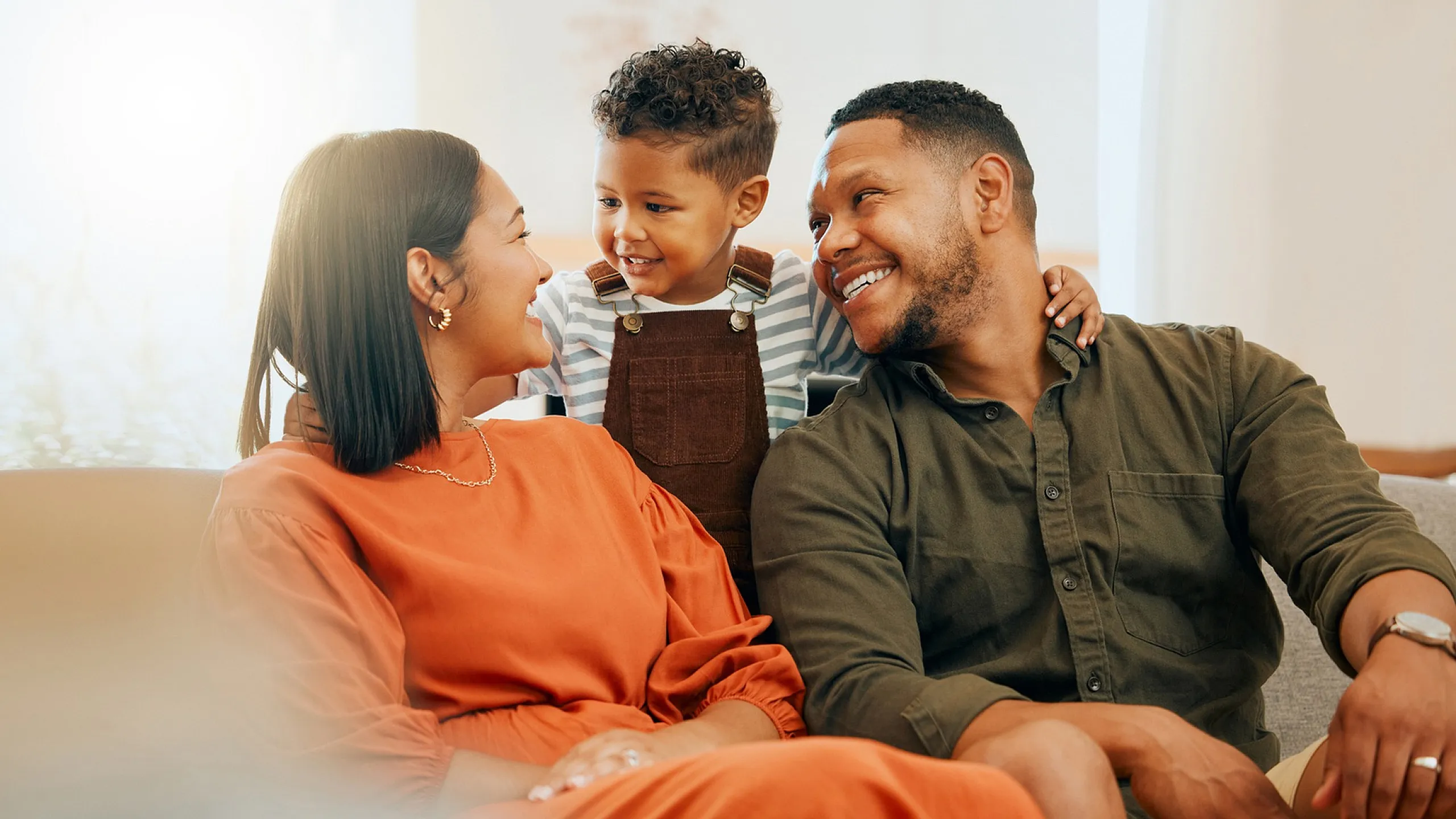 Happy family enjoying quality time together on a cozy sofa in a bright, inviting living room.