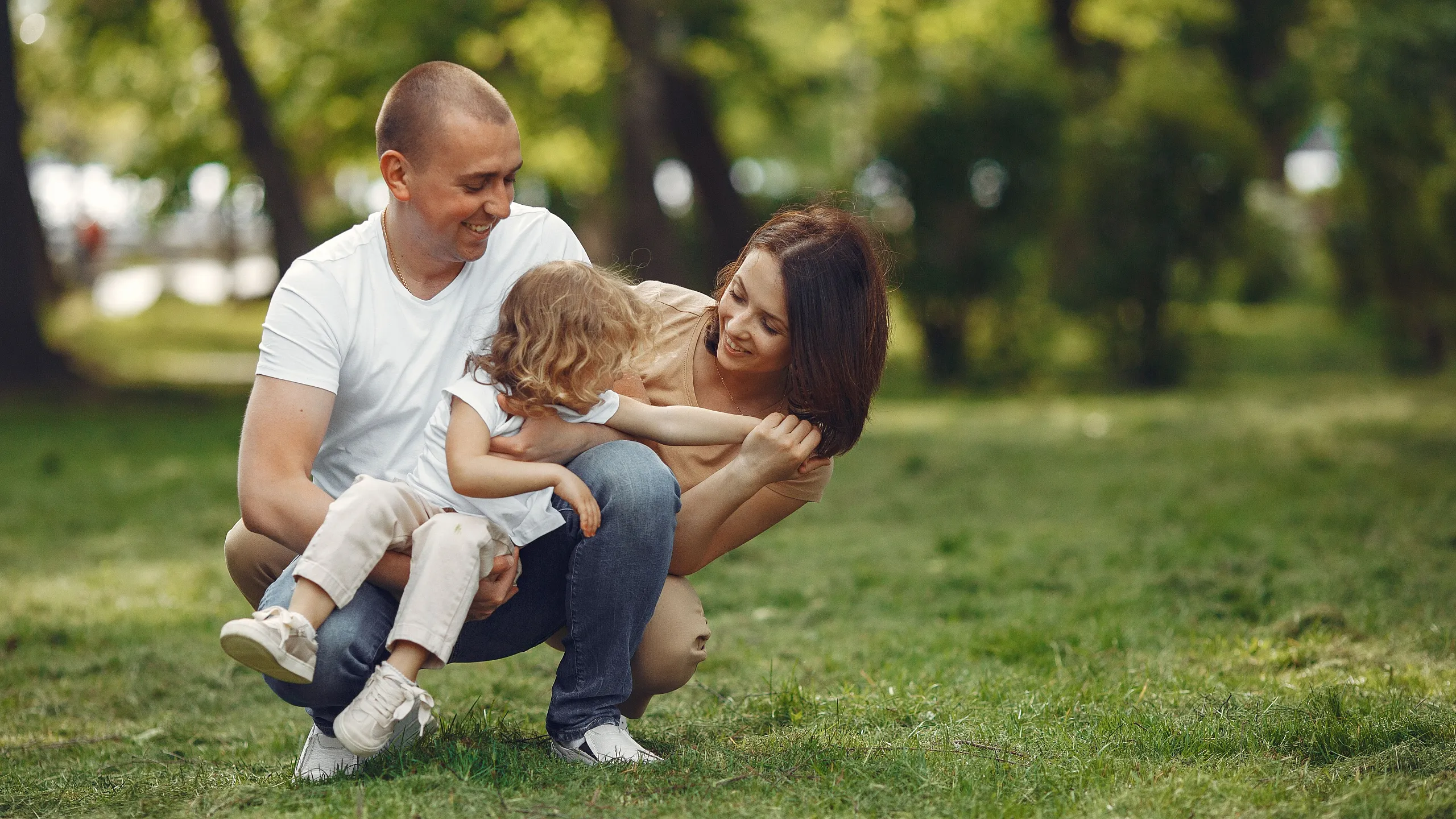 Happy family enjoying a sunny day in a lush green park, creating joyful memories outdoors.