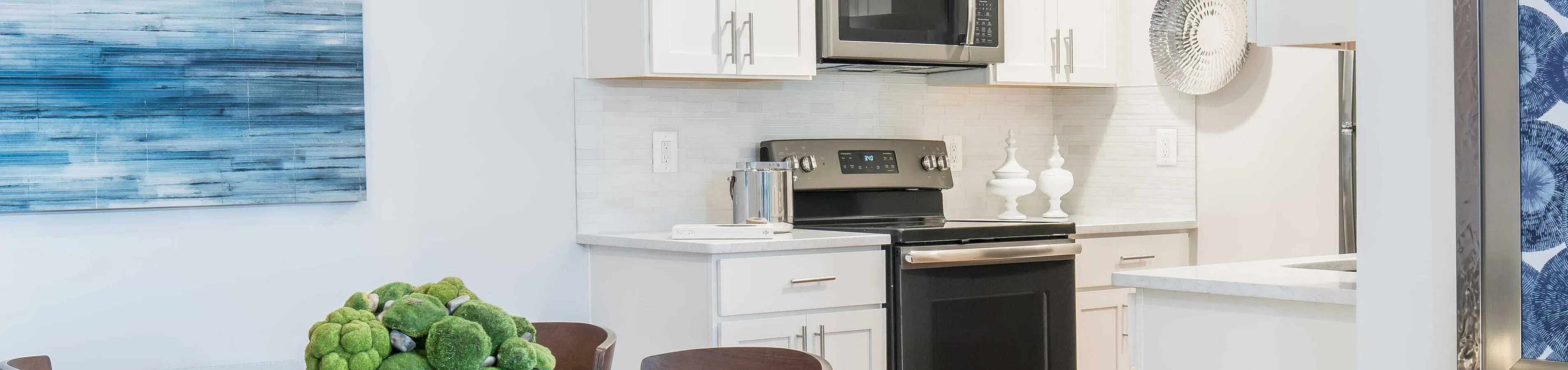 Chic modern kitchen with sleek appliances, glass-top dining table, and elegant decor. Ideal for stylish living and entertaining.