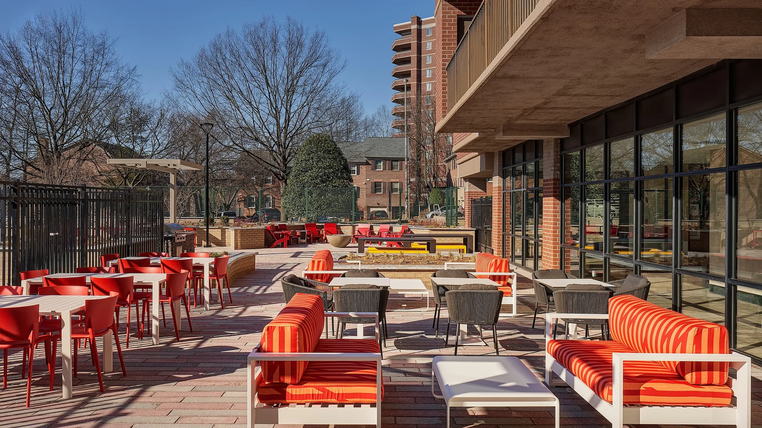 Vibrant outdoor patio area with modern red and black seating, offering a stylish and inviting space for relaxation and socializing.