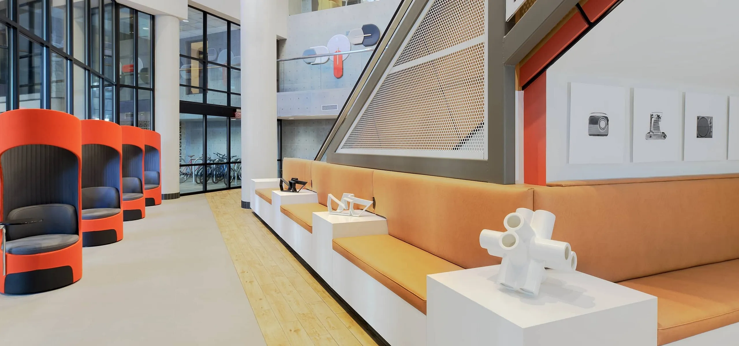 Modern lobby featuring vibrant seating pods, contemporary art, and sleek architectural design for a captivating first impression.
