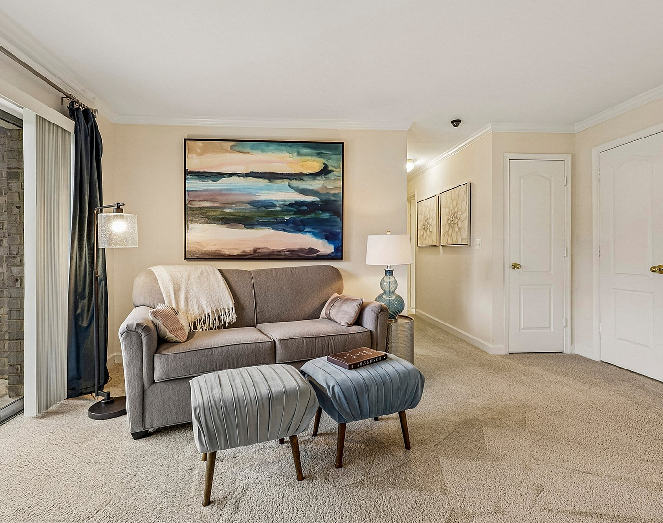 Cozy living room with elegant decor, featuring a plush gray sofa, abstract wall art, and soft lighting creating a warm atmosphere.
