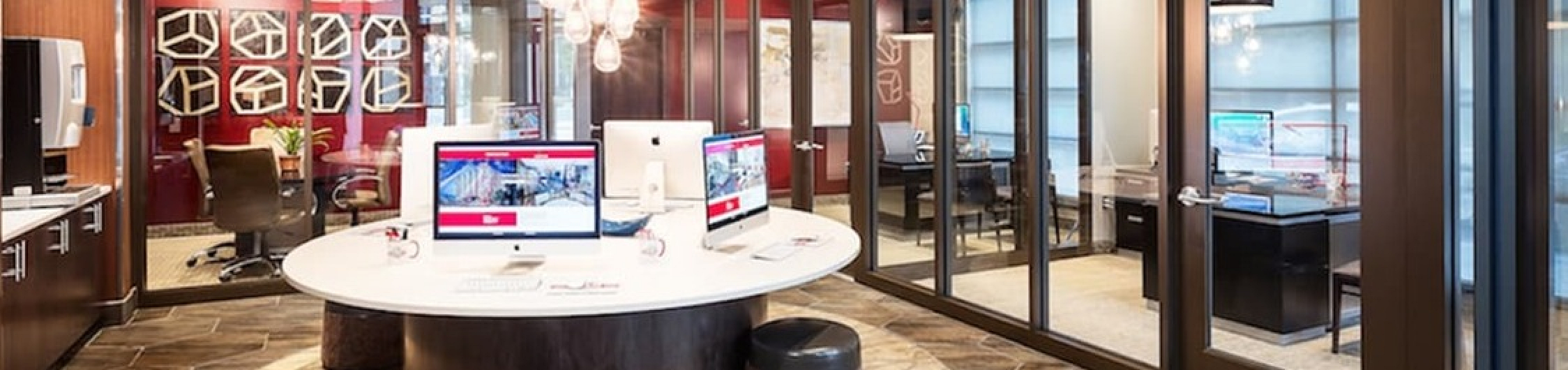 Modern workspace with sleek design, featuring a round table, stylish lighting, and glass partition walls for enhanced productivity.
