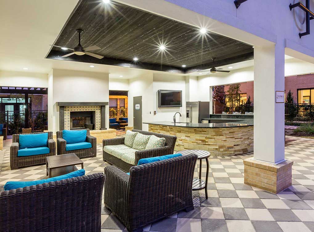 Evening view of outdoor kitchen, fireplace and television.