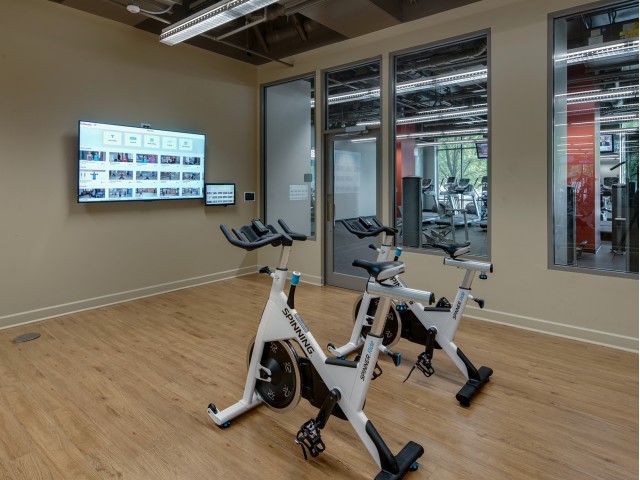 Two spin bikes in fitness center with TV screen for on demand classes