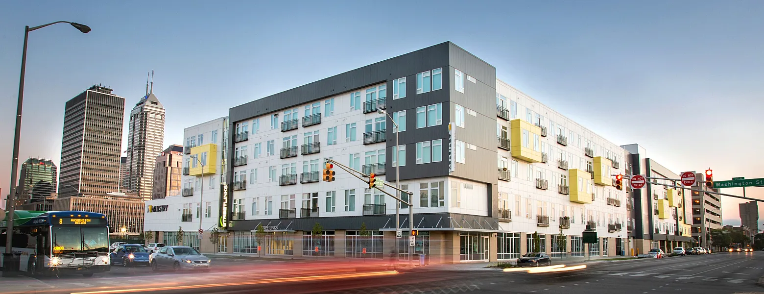Contemporary apartment building in urban cityscape at dusk with streetview.