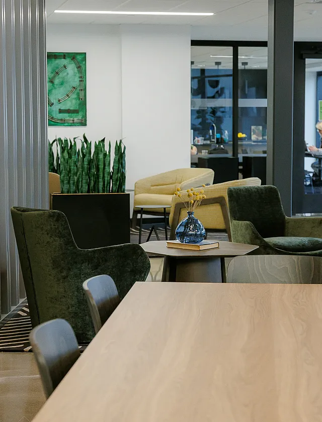 Modern shared lounge area with elegant chairs, stylish decor, and ample natural light.