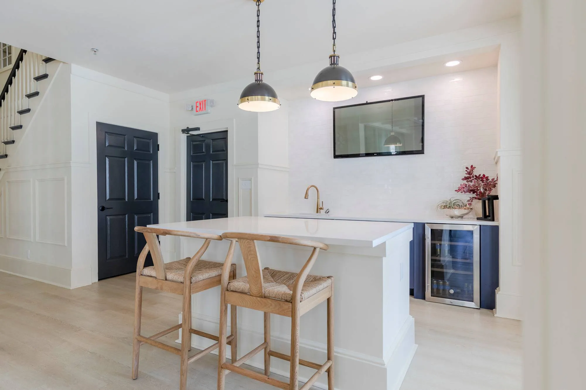 kitchen island with sink and chairs in clubroom