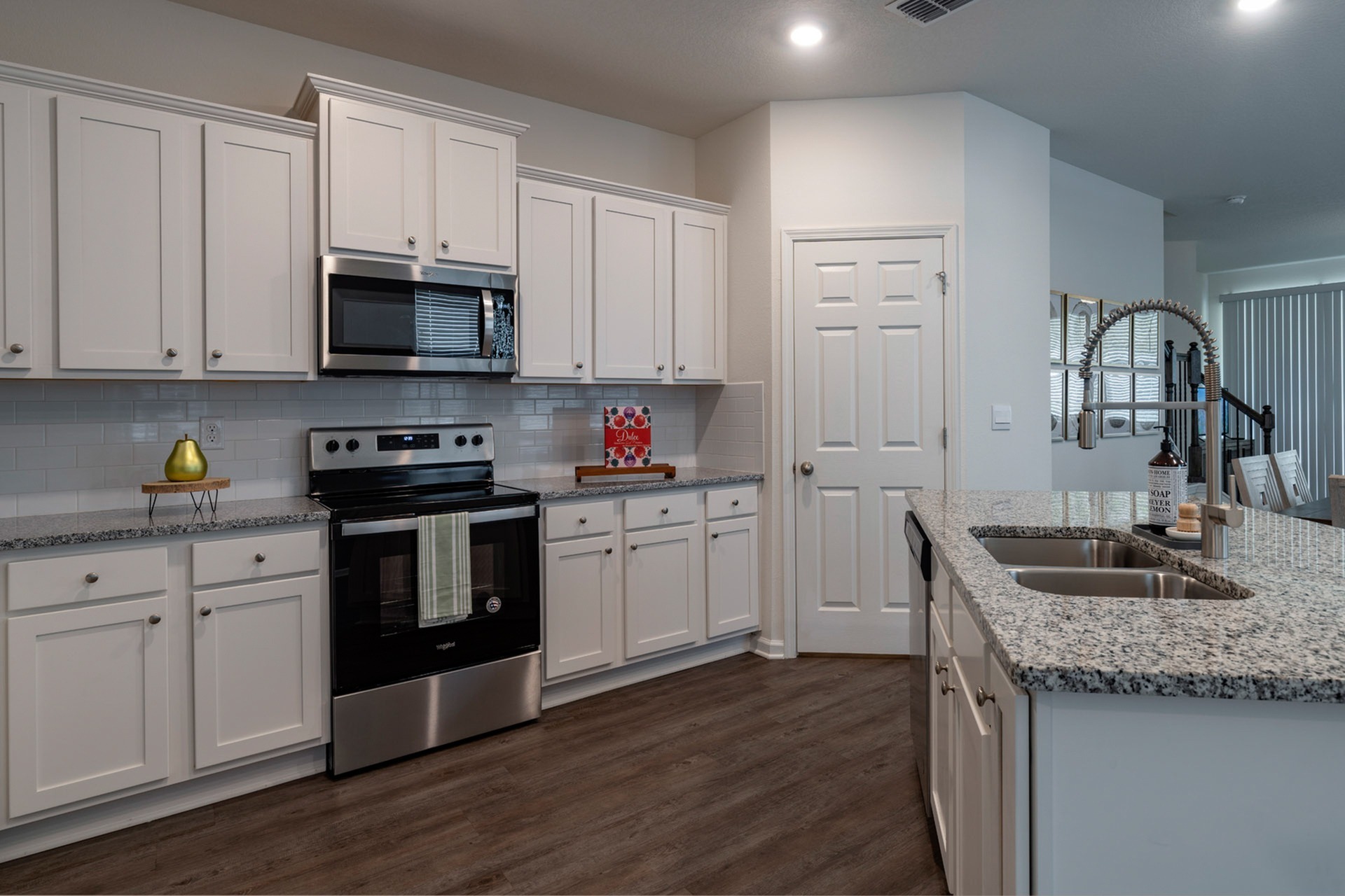 Kitchen with white cabinets and stainless steel and black appliances