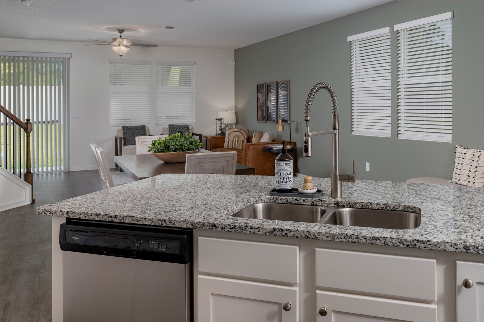 Kitchen with white cabinets and stainless steel and black appliances with view of the living room