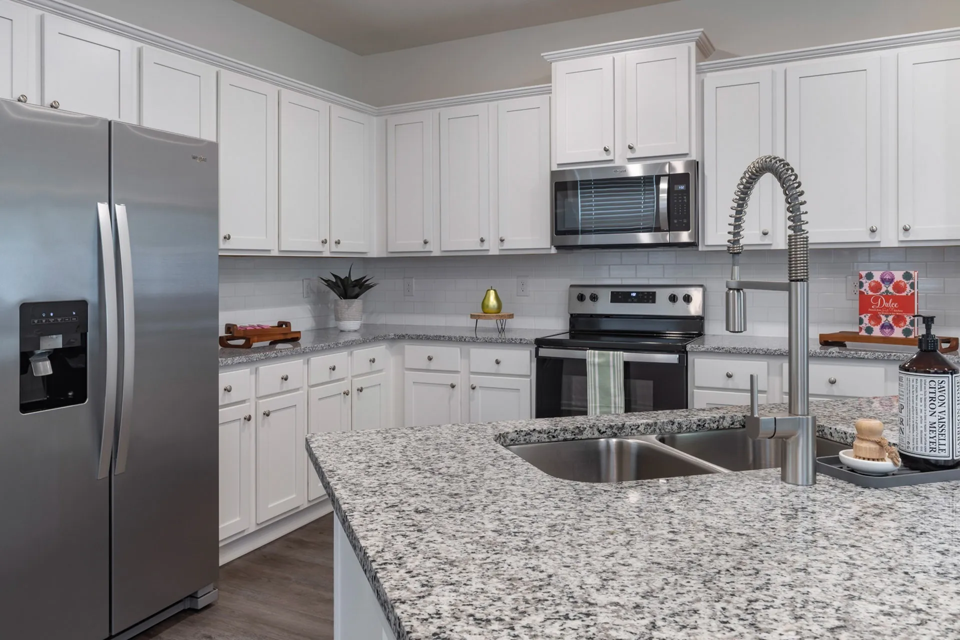 Kitchen with white cabinets and stainless steel and black appliances