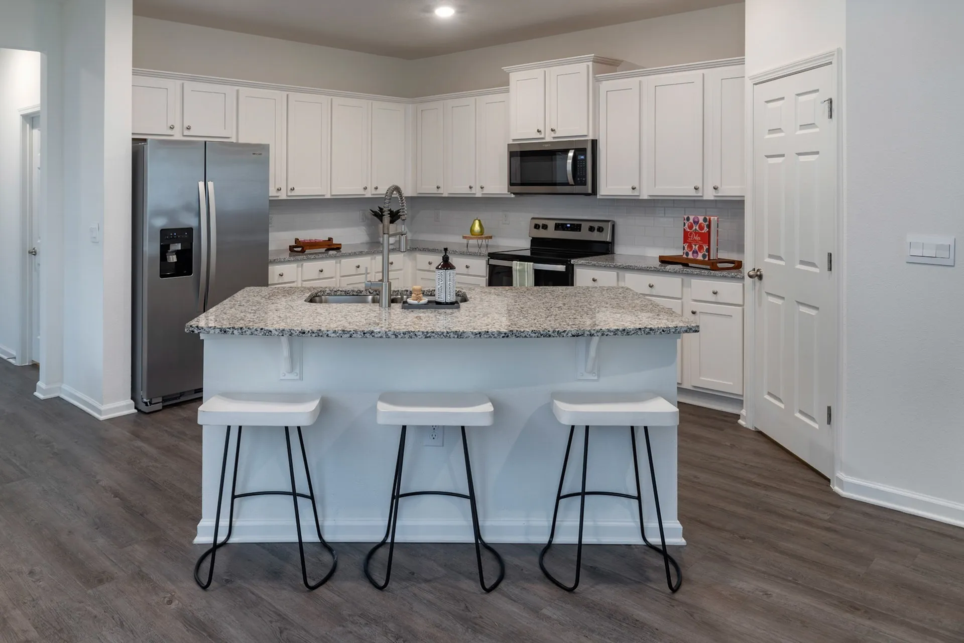 Kitchen with white cabinets and stainless steel and black appliances