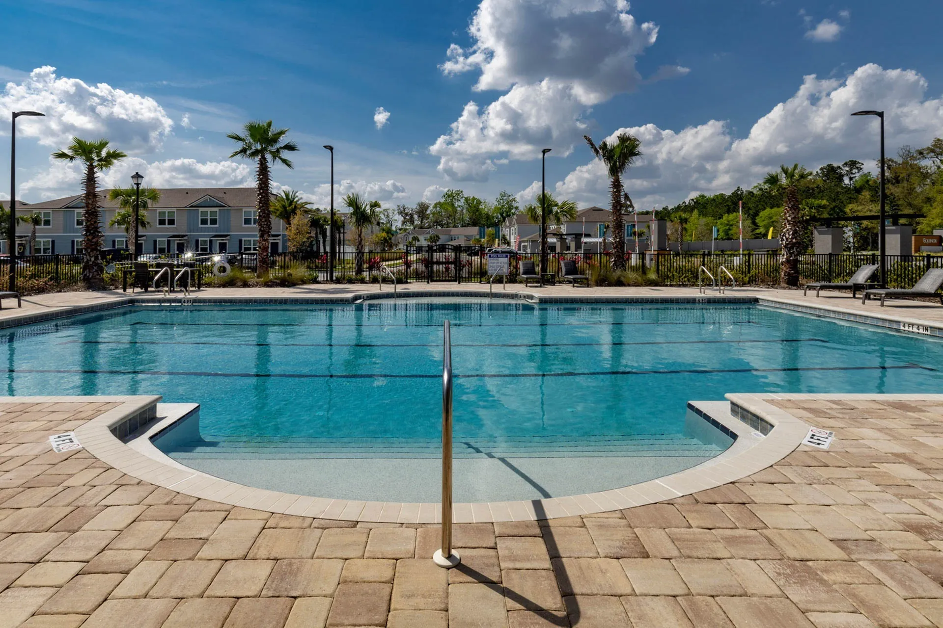 Outdoor pool with community in the background in the daytime